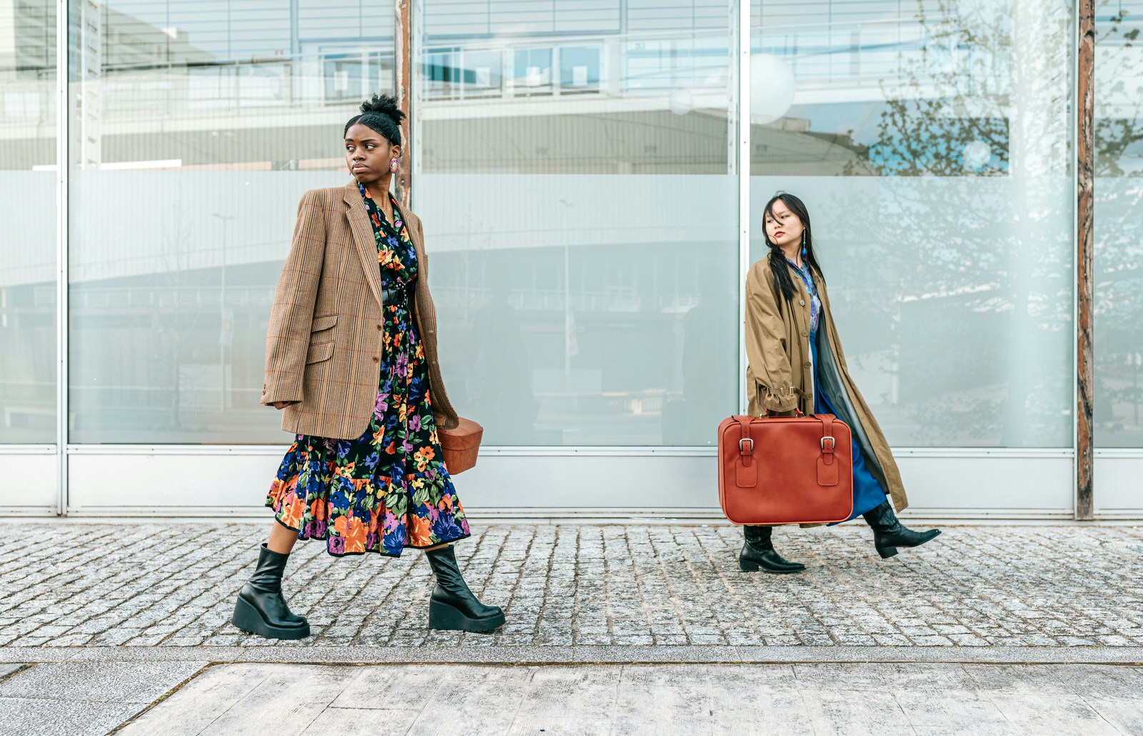 Deux femmes marchant sur le trottoir avec des valises.